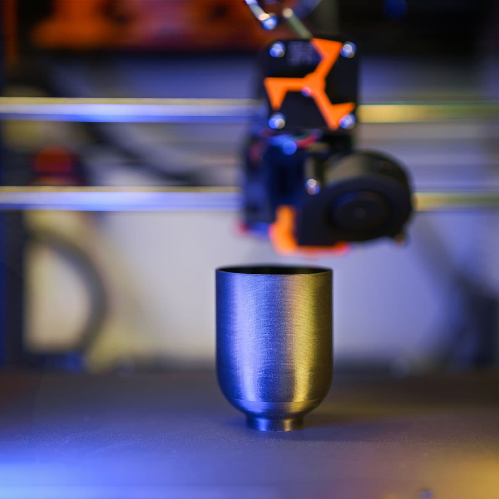 Extruderul unei imprimante 3D deasupra unei piese cilindrice în lucru